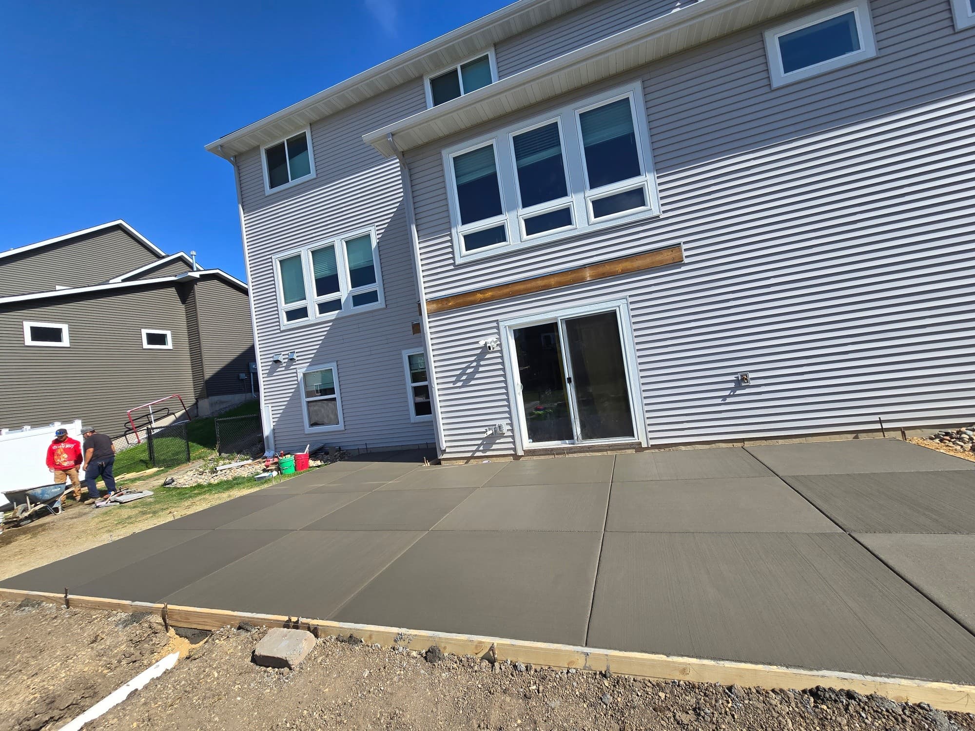 Primos Concrete LLC crew finishing a backyard concrete patio